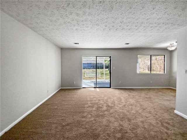 carpeted spare room with a textured ceiling