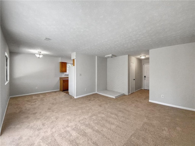 interior space with a textured ceiling and light carpet