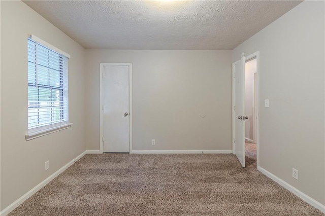 2045 Scarbrough Dr, Stone Mountain, GA 30088 - spare room with a textured ceiling, carpet flooring, and baseboards