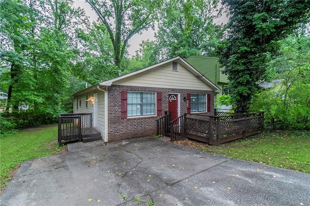 2045 Scarbrough Dr, Stone Mountain, GA 30088 - view of front facade with brick siding, a wooden deck, and a front lawn