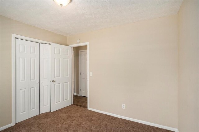 896 Meadow Rock Way, Stone Mountain, GA 30083 - unfurnished bedroom with carpet, a textured ceiling, and a closet