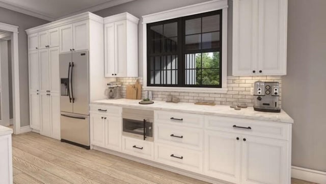 interior space with light wood-style flooring, backsplash, stainless steel refrigerator with ice dispenser, white cabinetry, and light stone countertops