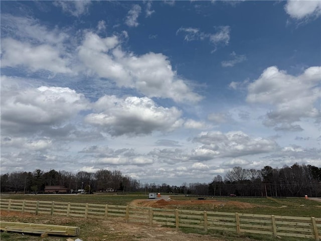 view of yard with fence and a rural view