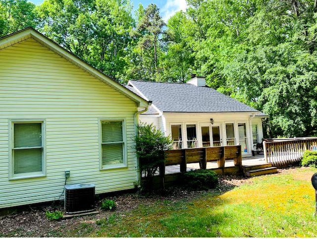 rear view of house featuring central AC, a yard, and a wooden deck