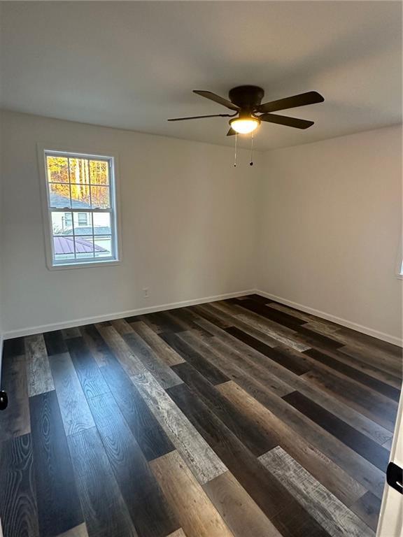 unfurnished room with ceiling fan and dark hardwood / wood-style floors