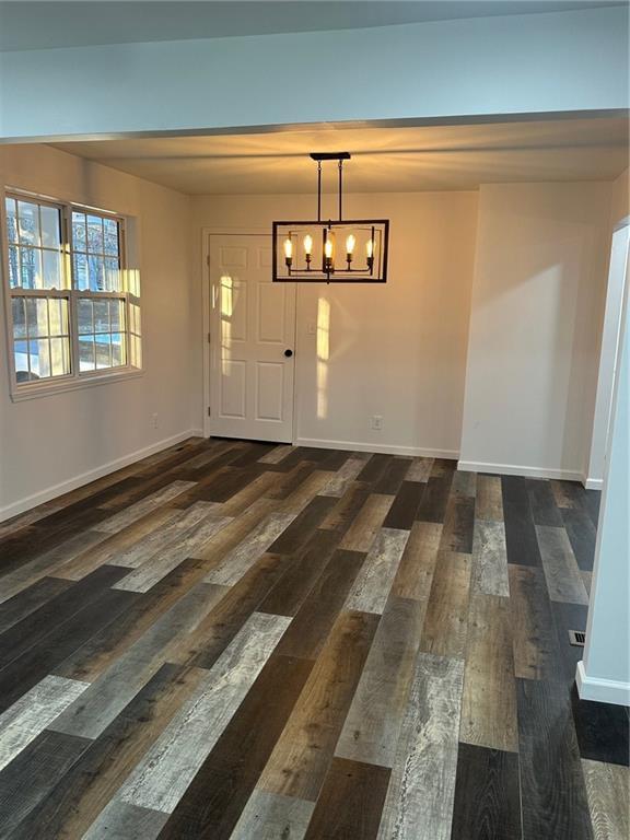 foyer entrance featuring dark wood-type flooring and an inviting chandelier