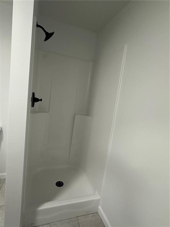 bathroom with a shower and tile patterned floors