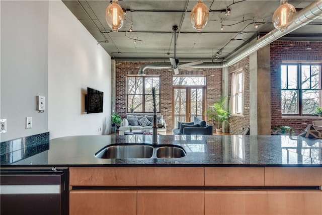 kitchen featuring brick wall and dark stone counters