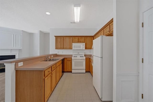 kitchen with sink, white appliances, light tile patterned flooring, and kitchen peninsula