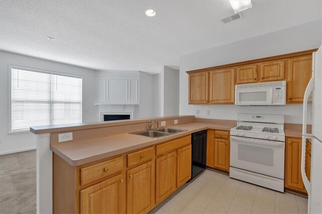 kitchen featuring sink, white appliances, a textured ceiling, light tile patterned floors, and kitchen peninsula