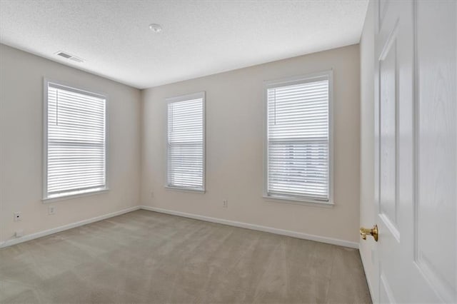 carpeted spare room with a textured ceiling