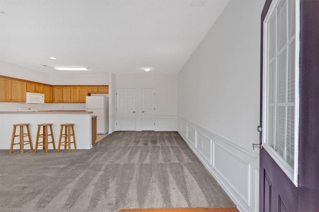 unfurnished living room featuring light colored carpet