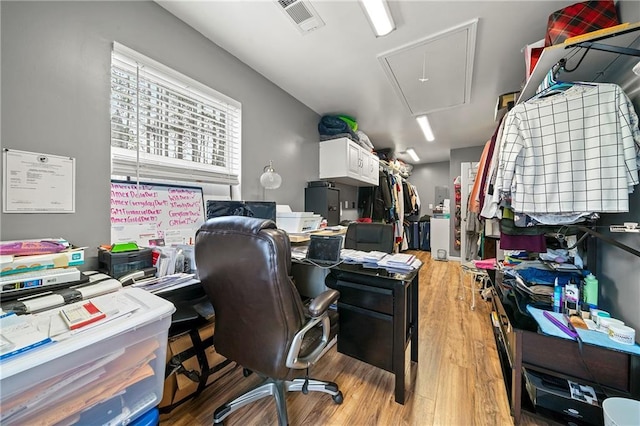 office featuring light wood-style floors, attic access, and visible vents