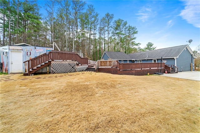 view of yard featuring a storage shed, a wooden deck, and an outbuilding