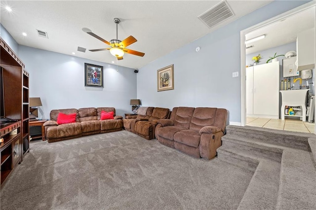 carpeted living area featuring visible vents, ceiling fan, and tile patterned floors