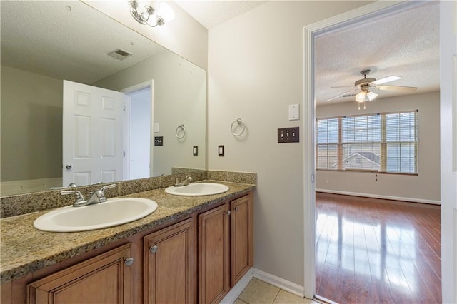 4844 W Park Cir Unit 4844, College Park, GA 30349 - bathroom featuring baseboards, a textured ceiling, a ceiling fan, and double vanity