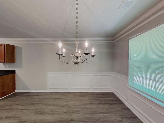 unfurnished dining area with crown molding, a chandelier, and dark wood-style flooring