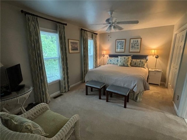 carpeted bedroom featuring ceiling fan and a closet