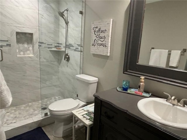 bathroom featuring vanity, toilet, and a shower with door