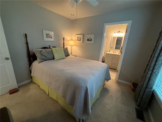 bedroom with light carpet, connected bathroom, and ceiling fan