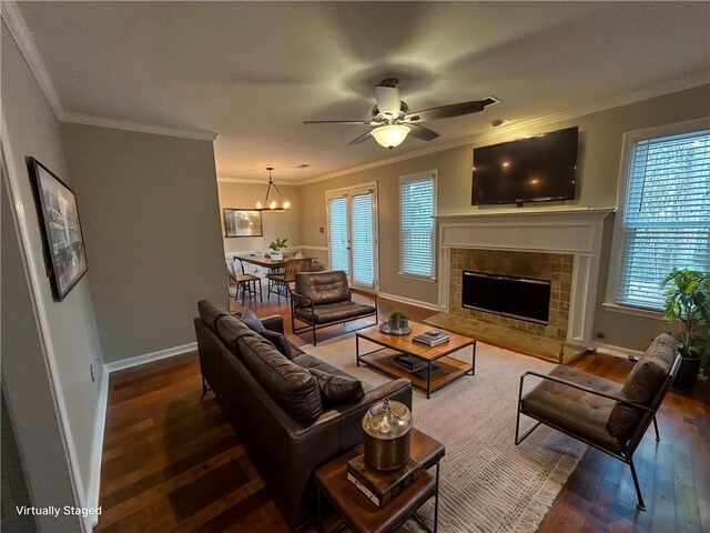 living room with crown molding, hardwood / wood-style flooring, a fireplace, and a healthy amount of sunlight