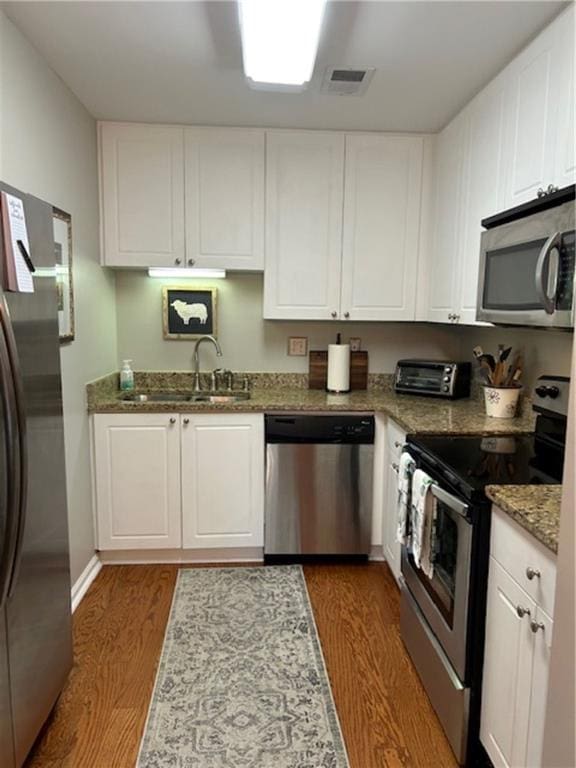 kitchen featuring white cabinets, dark hardwood / wood-style flooring, sink, and stainless steel appliances