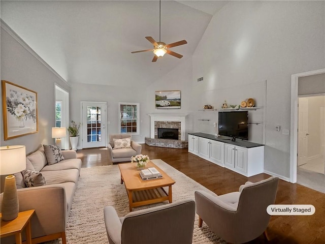 living room featuring ceiling fan, wood-type flooring, a fireplace, and high vaulted ceiling