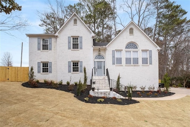 view of front of house with brick siding and fence