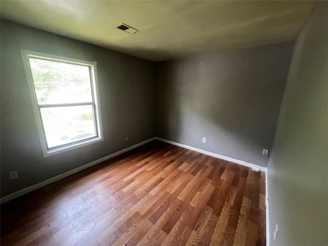 spare room with dark wood finished floors and baseboards