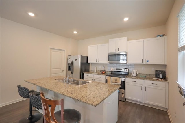 357 Hughes Ln, Pendergrass, GA 30567 - kitchen featuring stainless steel appliances, dark wood-type flooring, a center island with sink, white cabinetry, and a kitchen bar