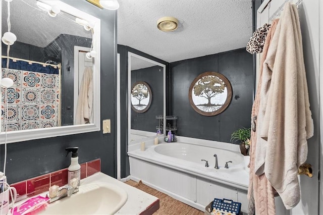 bathroom with a shower with curtain, wood finished floors, a sink, a textured ceiling, and a garden tub