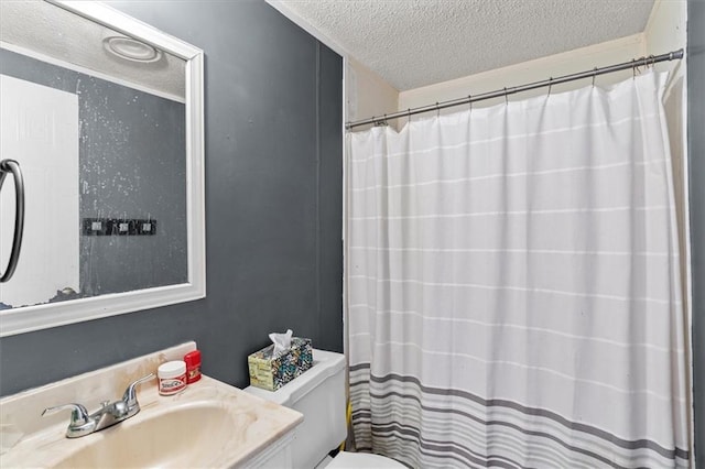 bathroom with vanity, curtained shower, toilet, and a textured ceiling