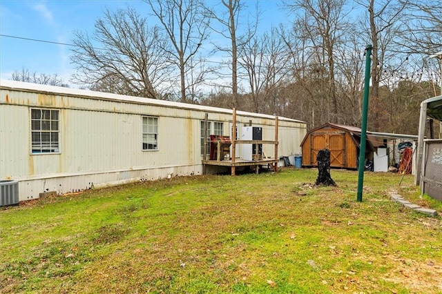 view of yard with cooling unit, a carport, an outdoor structure, and a shed