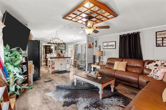 living room with light wood finished floors, a textured ceiling, crown molding, and vaulted ceiling