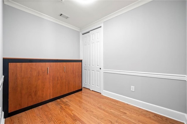 unfurnished room featuring light hardwood / wood-style flooring and crown molding