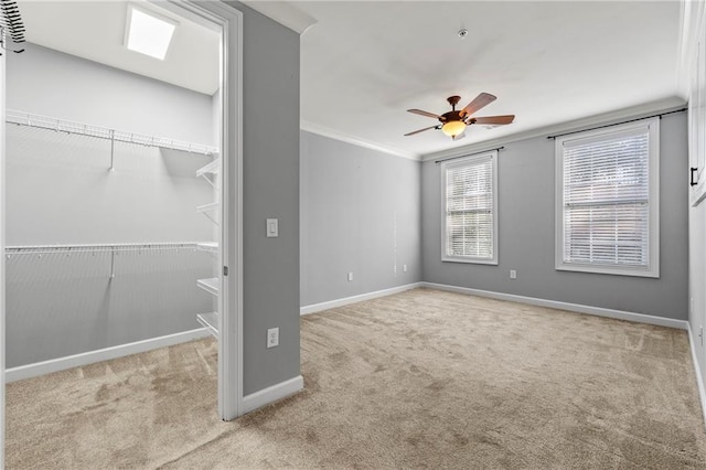 carpeted spare room featuring ceiling fan and ornamental molding