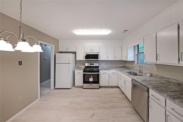 5807 Christopher Ln, Lithonia, GA 30058 - kitchen with stainless steel appliances, a sink, a chandelier, white cabinetry, and light wood-style floors