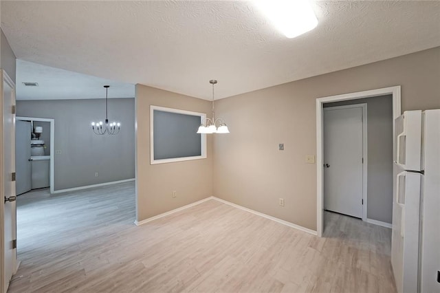 5807 Christopher Ln, Lithonia, GA 30058 - empty room featuring a chandelier, light wood-style flooring, baseboards, and a textured ceiling
