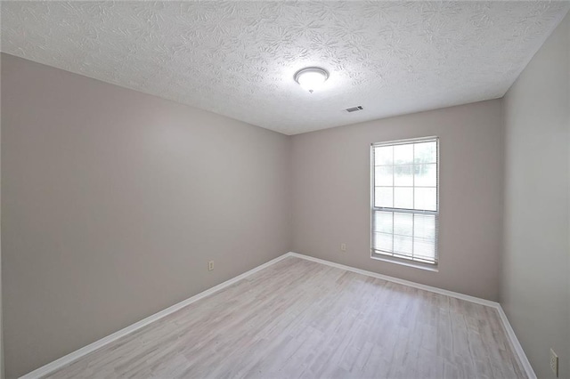 5807 Christopher Ln, Lithonia, GA 30058 - spare room with light wood-type flooring, baseboards, and a textured ceiling