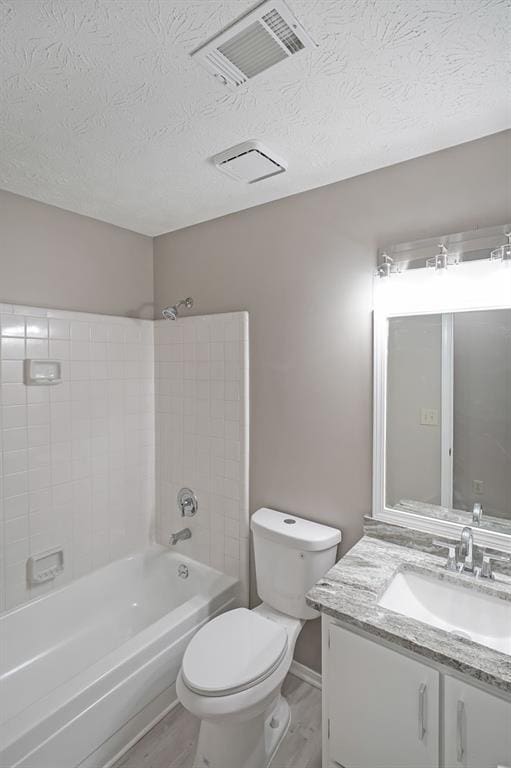 5807 Christopher Ln, Lithonia, GA 30058 - bathroom with toilet, wood finished floors, a textured ceiling, vanity, and shower / washtub combination