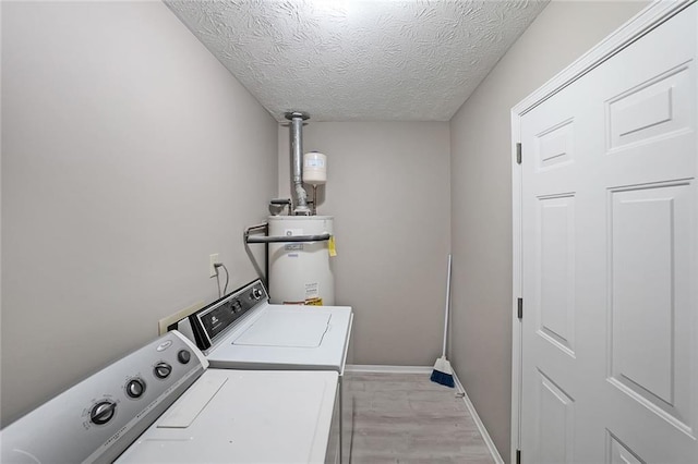 5807 Christopher Ln, Lithonia, GA 30058 - laundry area featuring water heater, washer and clothes dryer, light wood-style flooring, a textured ceiling, and baseboards