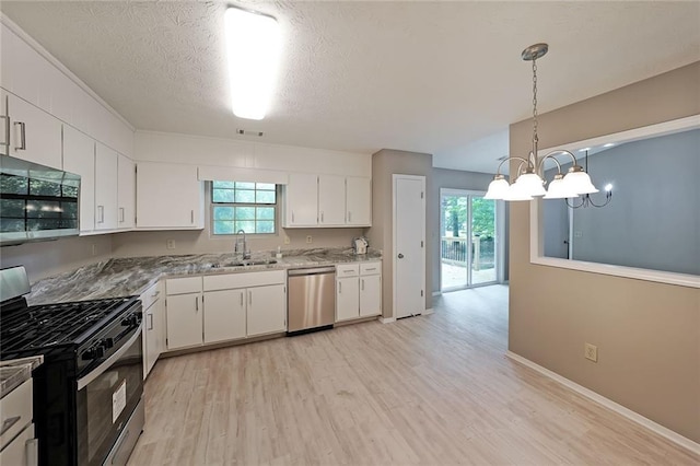 5807 Christopher Ln, Lithonia, GA 30058 - kitchen featuring appliances with stainless steel finishes, a sink, a chandelier, light wood-style floors, and white cabinetry