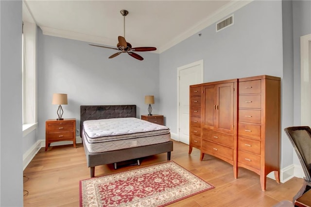 bedroom with ceiling fan, crown molding, and light hardwood / wood-style flooring