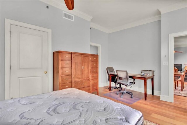 bedroom with ceiling fan, wood-type flooring, and crown molding