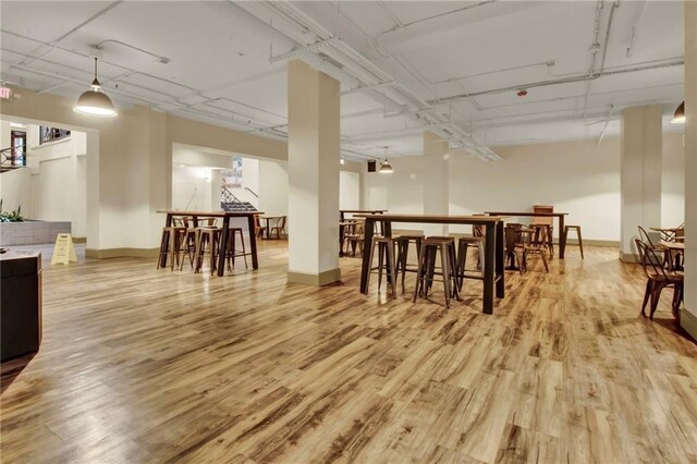 dining room with light wood-type flooring and bar