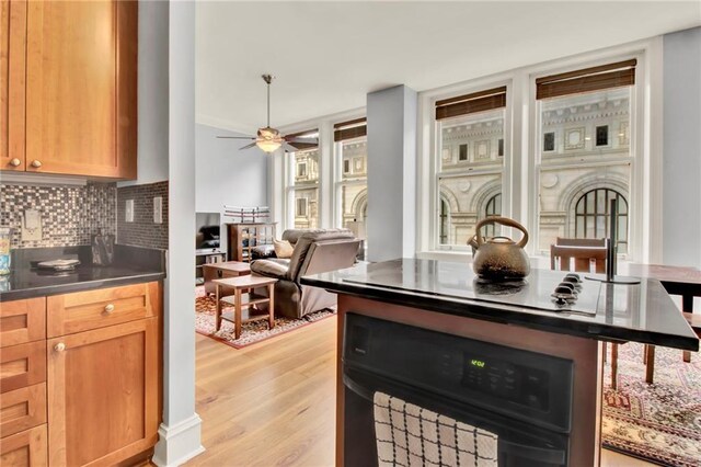 kitchen with ceiling fan, backsplash, black oven, white electric stovetop, and light wood-type flooring