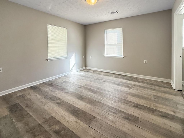 empty room featuring wood-type flooring and a textured ceiling