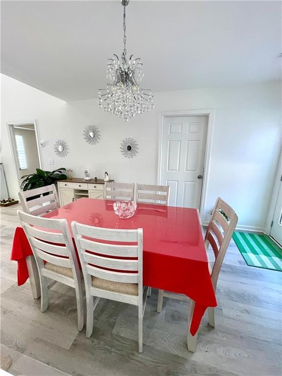 dining space with a notable chandelier and light wood-style flooring