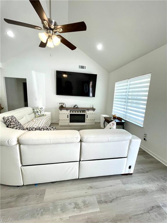 living room featuring visible vents, high vaulted ceiling, a ceiling fan, wood finished floors, and recessed lighting