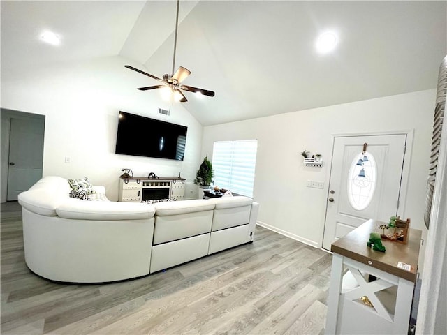 living room with baseboards, light wood-style floors, ceiling fan, and high vaulted ceiling